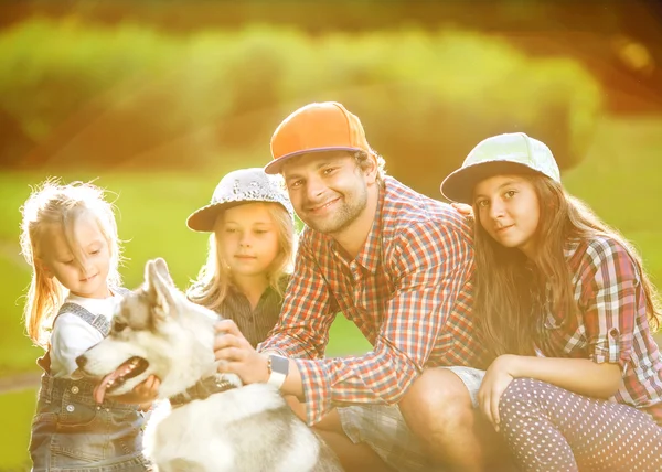 Baba ve iki kızı köpek husky ile parkta geçirmek eğlenceli zaman. — Stok fotoğraf