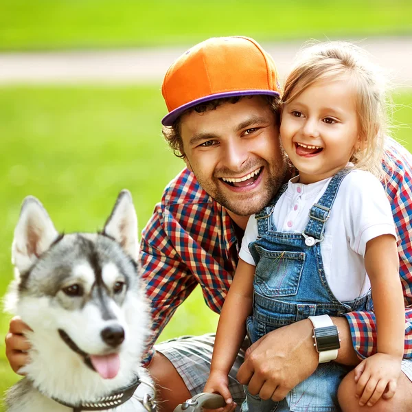 Vader en dochter spelen in het park in liefde met hond husky — Stockfoto