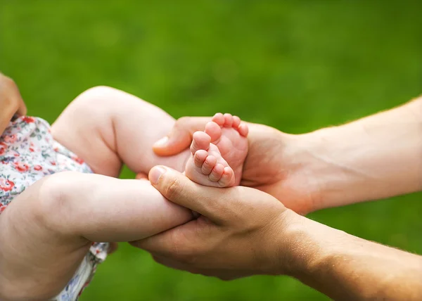 Pieds de bébé coupés en mains de pères . — Photo