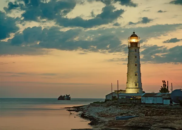 Старый маяк на берегу моря — стоковое фото