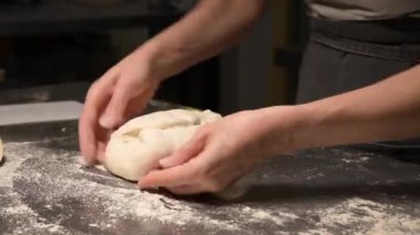 Profesyonel hızlı hareketleri olan bir fırıncının kadın ellerini çeken sinematik canlı kamera, pişirmeden önce bir zanaatkar ekmeğinin hamurunu yoğurur.