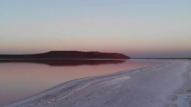 Pembe Tuz Gölü 'nde havadan aşağıya doğru eğimli. Sinematik film tahılları. İyi akşamlar. Doğal üretilmiş Sağlıklı Pembe Tuz