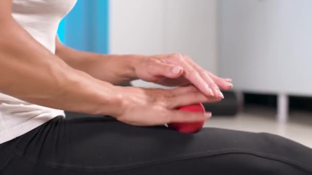 Deportiva mujer caucásica delgada haciendo auto-masaje del muslo en la esterilla de fitness con bola de masaje en el interior. Masaje de autoaislamiento — Vídeos de Stock