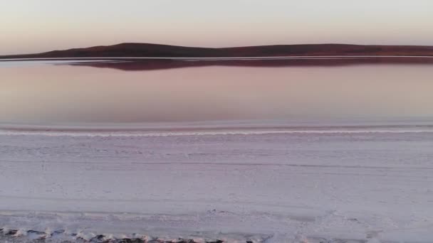 Vue aérienne Incliné vers le bas dans le lac salé rose discret. Film cinématographique grain. Coup de feu du soir. Sel rose sain produit naturellement — Video