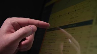 Karanlık bir yapım odasındaki dokunmatik ekranda endüstriyel teknolojiyi ayarlayan bir adamın yakın çekimi. Canlı kamera. Reklam üretimi