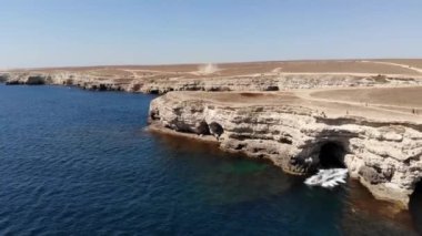 Tozlu bir şeytan, kumlu bir kıyıdaki bir kasırga kuru bir çalılığın içinden şiddetle geçer. Bozkır manzaralı tozlu arazi turistleri. Doğal fenomen