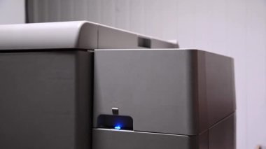 Adam kağıda basmak için yazıcının kapağını açıyor ve kağıt yüklemek için karton kullanıyor. Yakın plan.