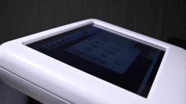 Karanlık bir yapım odasındaki dokunmatik ekranda endüstriyel teknolojiyi ayarlayan bir adamın yakın çekimi. Canlı kamera. Reklam üretimi