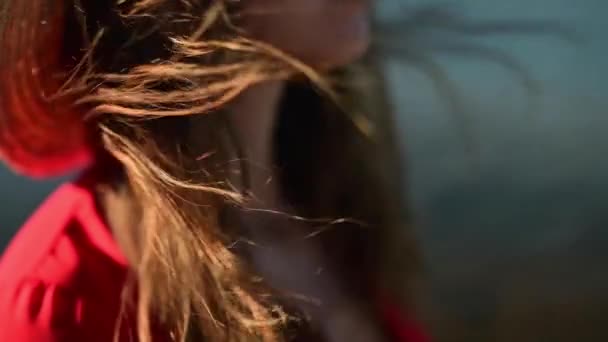 Крупним планом Повільний рух обличчя прекрасної кавказької молодої жінки з фокусу. Вітер пестить і ламає волосся. Зосередьтеся на волоссі. На тлі морського горизонту . — стокове відео