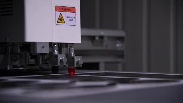 An industrial advertising plotter close-up cuts a template on the cardboard packaging for products. shallow depth of field in real time. Live camera — Stock Video