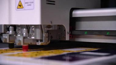 Endüstriyel bir reklam tasarımcısı ürünler için karton paketleme şablonunu kesiyor. Gerçek zamanlı olarak yüzeysel alan derinliği. Canlı kamera