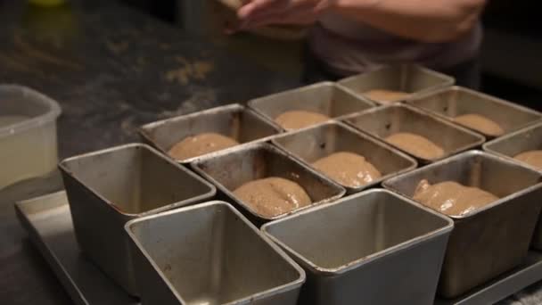 Die Frau legt den Teig in eine Brotpfanne. Brotbacken in der Handwerksbäckerei — Stockvideo