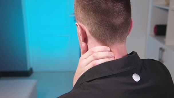 Närbild av en vit man som masserar nacken för sig själv. nacksmärta och förebyggande av nackproblem. — Stockvideo