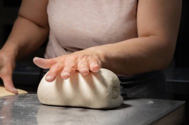 Yakın plan fırıncı ekmek yapıyor, kadın eli, yoğurma hamuru, yemek yapıyor.