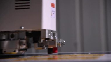 Endüstriyel bir reklam tasarımcısı ürünler için karton paketleme şablonunu kesiyor. Gerçek zamanlı olarak yüzeysel alan derinliği. Canlı kamera