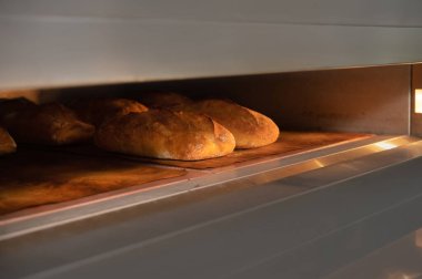 Endüstriyel bir fırında üç somun hamur ekmeği pişirilir. Ekmek üretimi