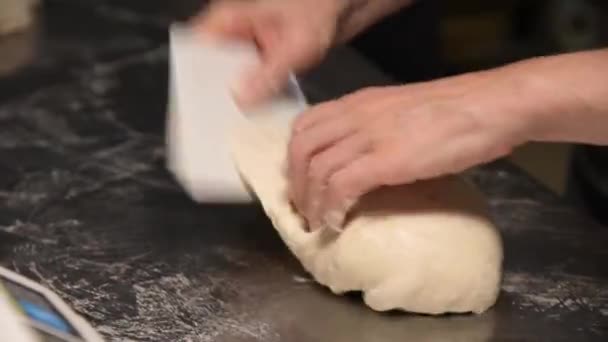Cinematic live camera schoot vrouwelijke handen van een bakker met professionele snelle bewegingen kneedt het deeg van een ambachtelijk brood brood brood voor het bakken — Stockvideo