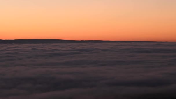 Filmvetítés 4K. Időpont naplemente után a felhők felett. A köd tengere rétegekből áll. A felhők felett véget ért. Lapos felület. Skyline piros alkonyat háttér videó — Stock videók