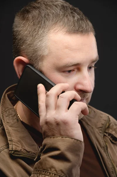 Niespokojny mężczyzna w średnim wieku dzwoni i rozmawia przez telefon. Zbliżenie. Portret studenta — Zdjęcie stockowe