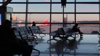 MOSCOW, RUSSIA - 21 Kasım 2021: Vnukovo Havaalanı Terminal Kapısı dolly vuruldu. İnsanlar, uçuşlarını bekliyorlar, oturup terminalde dolaşıyorlar.