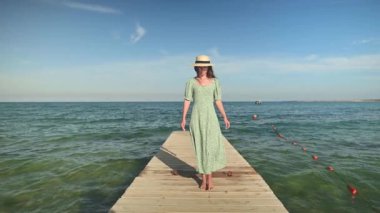 Ağır çekim kadın sahilde denizin tadını çıkarıyor. Okyanusu inceliyorum. Açık kahverengi saçlı bir kız.