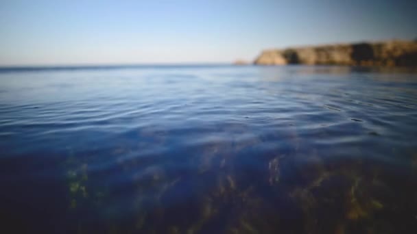 Närbild grunt skärpedjup lugn havsyta på en solig dag — Stockvideo