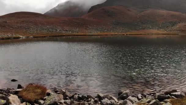 Pemandangan udara penerbangan sudut rendah di atas danau alpine di musim gugur. Keruh sekali. Awan di pegunungan. Pemanasan global. Sumber air murni 4k — Stok Video