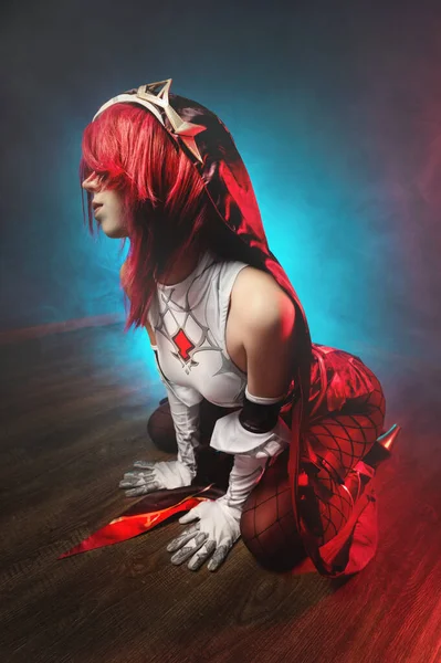 Cosplay. Retrato de estudio de atractiva mujer joven sexy en traje de rosario de anime con pelos rojos y guantes blancos. Postura sexual en el suelo en luz de color — Foto de Stock