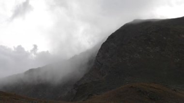 Dağ manzarası dağ kayalıkları ve akan bulutlar. Hava ve iklimi değiştirmek için arka plan. Küresel sıcaklık