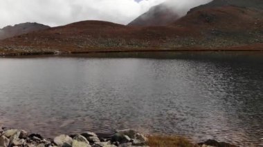 Alp gölü kıyısındaki uçuşu, kristal berrak içme suyuyla gösteren hava manzarası. Dokunulmamış doğanın korunan yerleri.