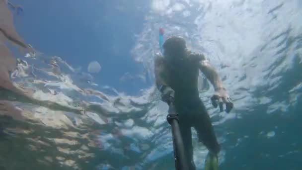 Jovem caucasiano nadando subaquático livre em máscara e snorkel com barbatanas tirando fotos de si mesmo na vara selfie e câmera de ação — Vídeo de Stock