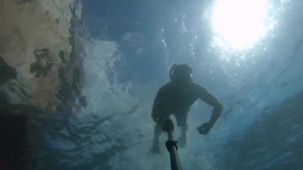 Joven buceo libre en una máscara nada bajo el agua junto a un barco hundido. Cámara de acción selfie stick — Vídeos de Stock