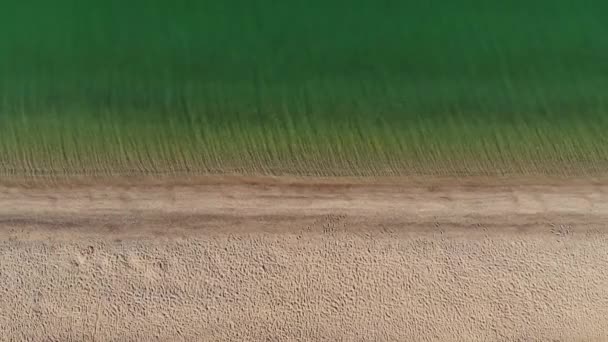 Vista aérea Praia e vista mar. Praia de areia com água azul-turquesa. Vista aérea da areia da praia, com vistas deslumbrantes das ondas, da costa e do lado azul-turquesa do oceano para relaxar no paraíso — Vídeo de Stock