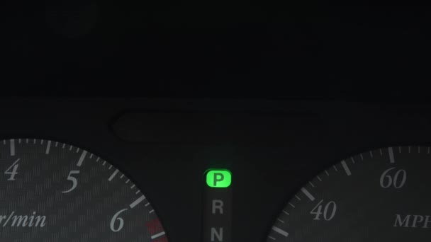 Karanlıkta parlayan yeşil tehlike ışığı olan bir araba paneli. Yakın plan. — Stok video