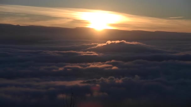 Timelapse above the clouds, the sun sets below the horizon. The movement of the clouds below — Video Stock