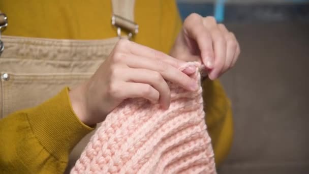 Close-up of female hands crocheting yarn. A lifestyle shot in daylight at home, sewing wool garments. — Stockvideo