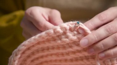 Örgü ören kadın ellerinin yakın çekimi. Gündüz vakti evde çekilen bir yaşam tarzı, yün elbiseler dikmek..