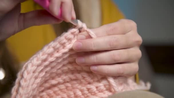 女性の手のクローズアップ糸をかぎ針編み。家庭で昼間に撮影されたライフスタイル、ウールの服を縫製. — ストック動画