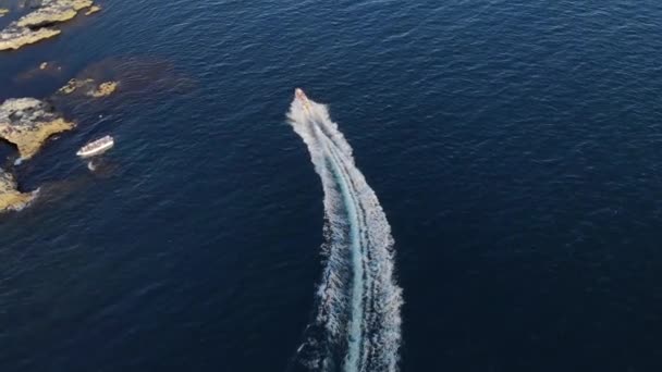 Una barca a motore turistica con turisti galleggia lungo la costa di un promontorio roccioso. Trasporti idrici turismo acqua — Video Stock