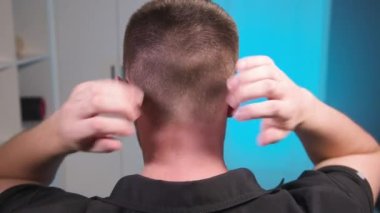 Kafkasyalı genç erkek masör kendi kendine masaj yapıyor. Yakın plan. Myofasceal salınımı