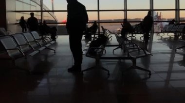 MOSCOW, RUSSIA - 21 Kasım 2021: Vnukovo Havaalanı Terminal Kapısı dolly vuruldu. İnsanlar, uçuşlarını bekliyorlar, oturup terminalde dolaşıyorlar.