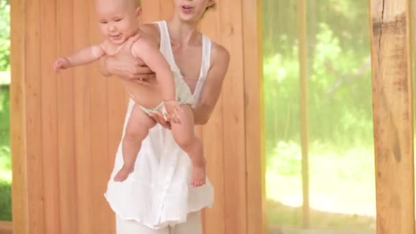 Een vrouwelijke beoefenaar in witte gewaden speelt met haar dochtertje in de oefenruimte. Levensduur van eco-nederzettingen van nieuwe leeftijd en downshifting. — Stockvideo