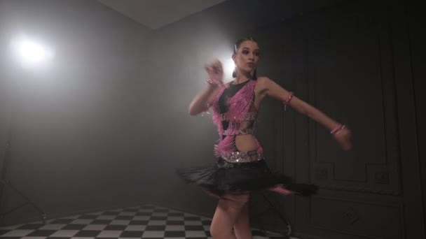 Привлекательная кавказская девушка в танцевальном платье в студии танцует элементы латиноамериканского танцевального направления. Низко. Бальные танцы — стоковое видео