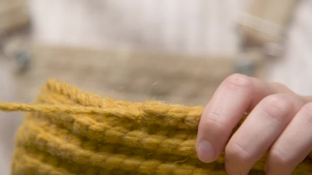 Gros plan d'une jeune femme caucasienne détache le fil faisant une erreur tout en tricotant un produit de laine — Video