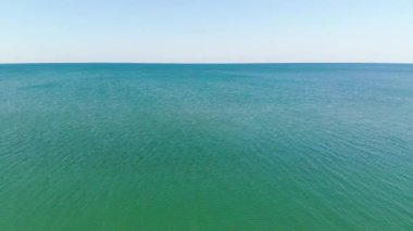 Okyanus yüzeyinde havadan uçuş. Açık denizde pürüzsüz bir ufuk. Deniz arkaplanı