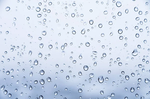 Капли воды на стекле натурального ярко-синего фона. Фон влажности — стоковое фото