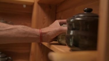 Çömlekçilerin yakın çekim güçlü elleri kendi elleriyle bitirilmiş teaware gösteriyor. Kravt çay seramiklerinin sunumu ve tanıtımı