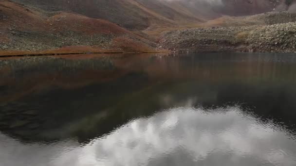 Tieffliegendes Luftbild des Alpensees ohne Vegetation. Rote Felsen am Abend — Stockvideo