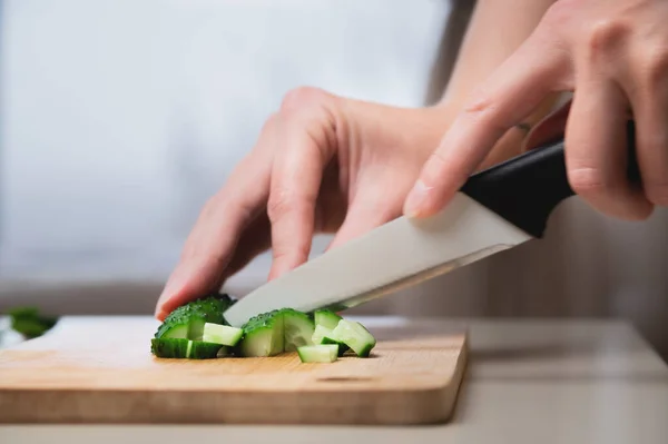 Close-up dari tangan wanita memotong mentimun untuk salad vegan. Masakan rumah sehat dan makanan sehat — Stok Foto