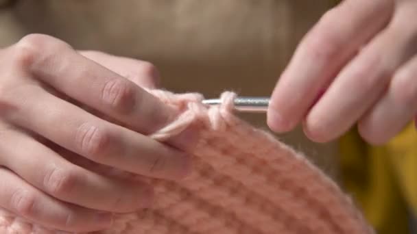 Gros plan de jeunes mains féminines d'une fille caucasienne faisant crochet, montre comment tricoter correctement. Profondeur de champ faible. plage dynamique élevée. — Video